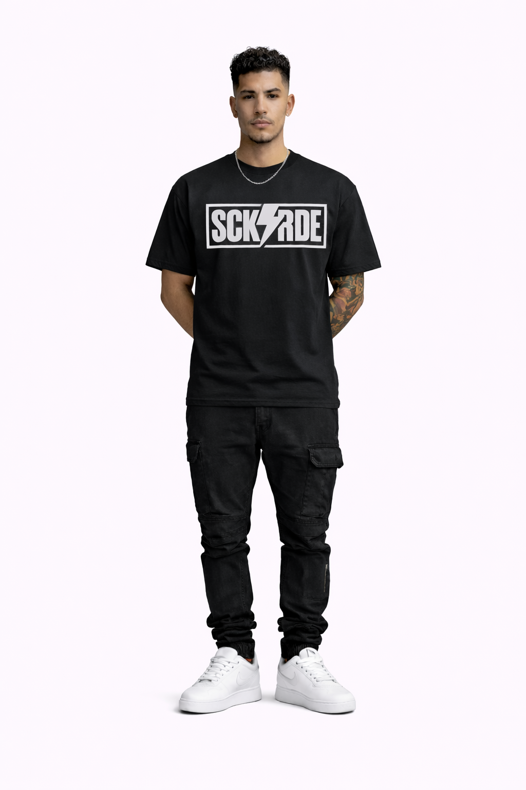 Man wearing a black t-shirt with a logo and black pants on a white background