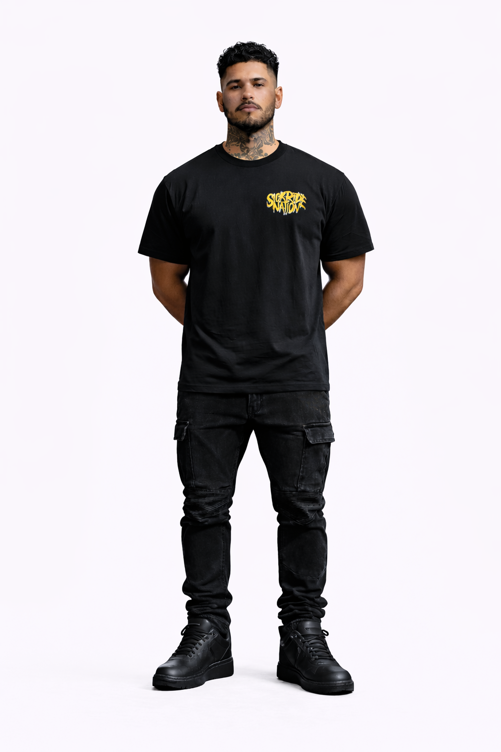 Man wearing a black t-shirt with a logo and dark pants on a white background