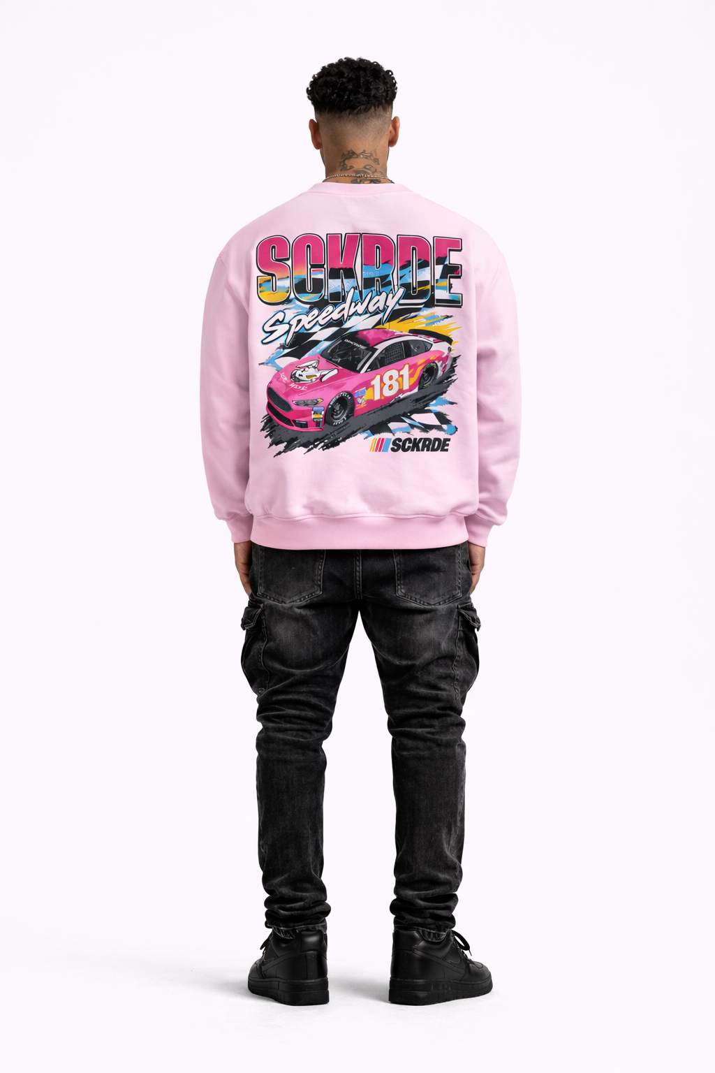 Person wearing a pink sweatshirt with a car graphic and 'Coyote Speed Shop' text on a white background