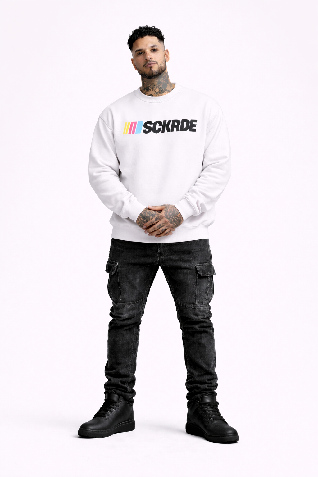 Man wearing a white sweatshirt with colorful text and black pants on a white background