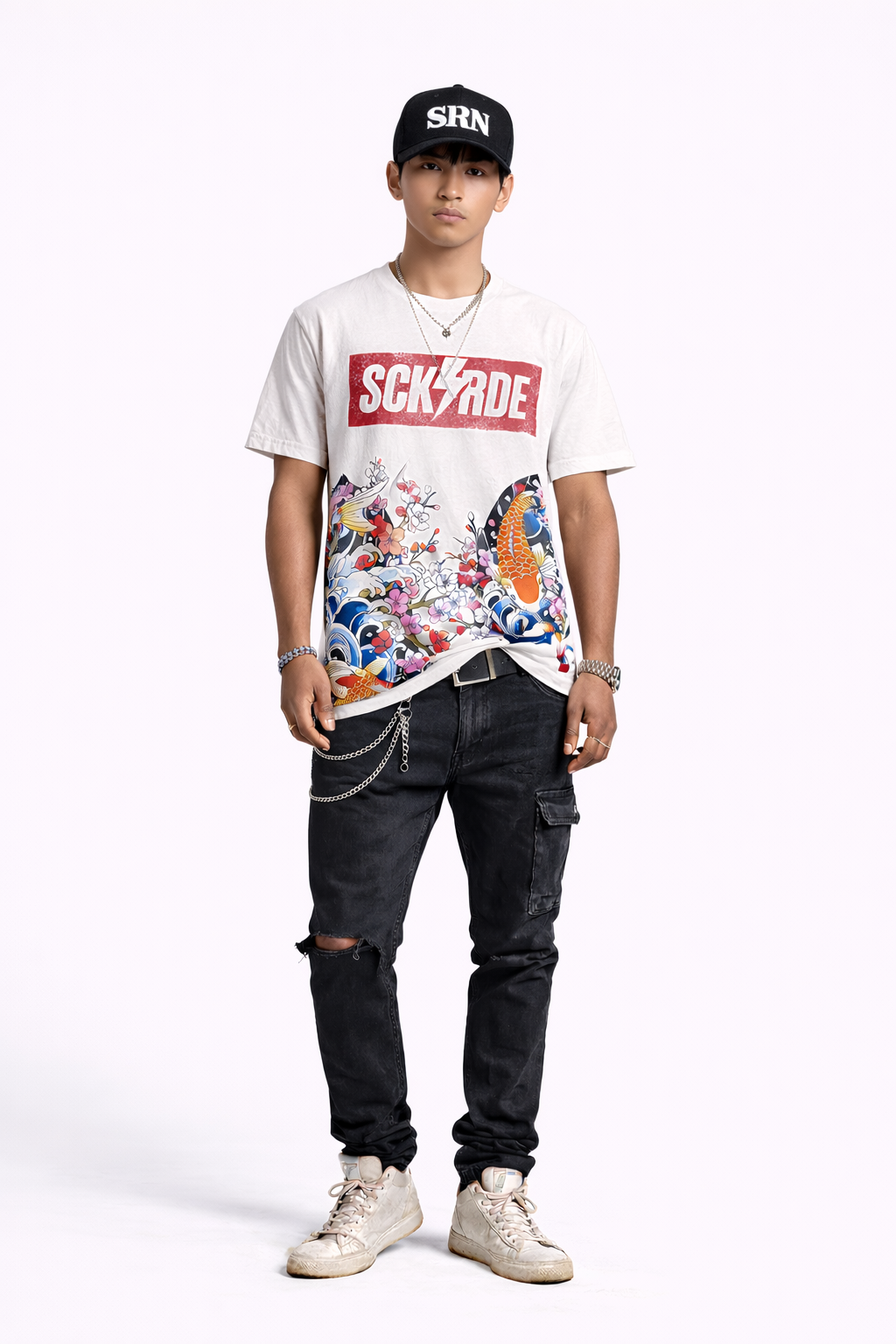 Person wearing a graphic t-shirt, black pants, and white sneakers on a white background